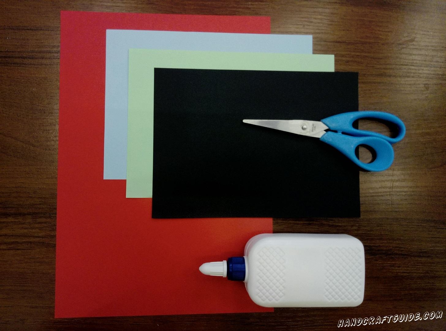 Для изготовление нам понадобится: Клей ПВА Ножницы Цветная бумага: красный лист формата А4; половинки листа А4 голубого, чёрного и бирюзового цвета