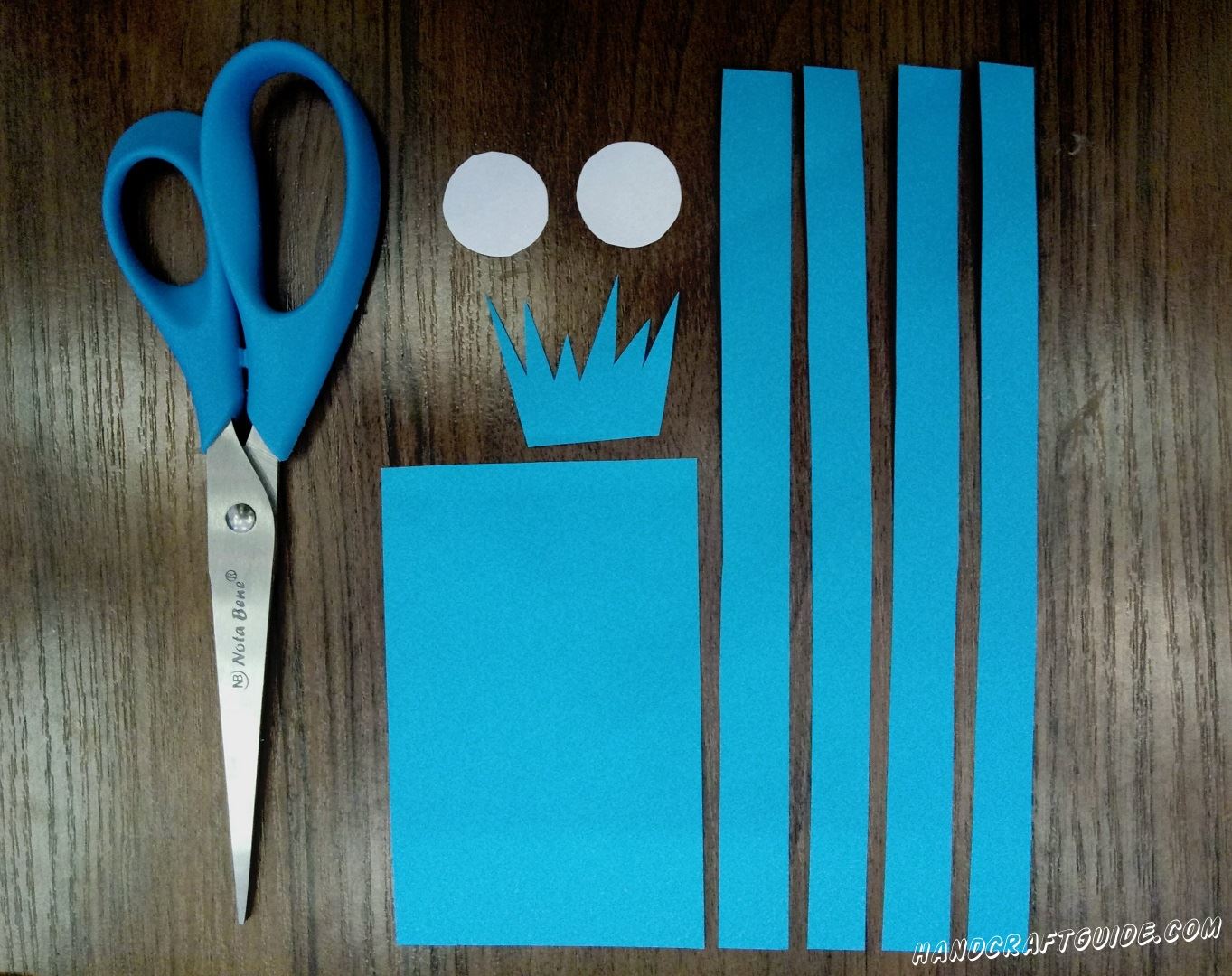 Cut out little figures of the blue construction paper like it is shown in the picture.