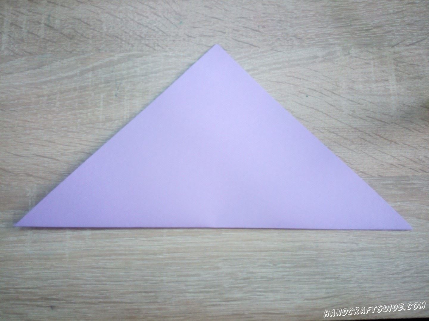 Возьмём бумагу для оригами или вырежем квадрат из цветной бумаги. Складываем треугольник