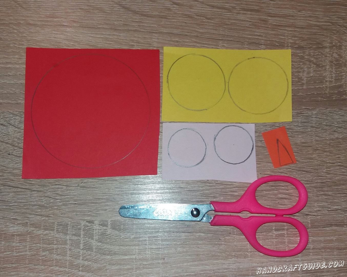 Для начала подготовим все необходимые нам детали. Нам нужно вырезать большой круг красного цвета, 2 меньших круга желтого цвета, 2 белых, самых маленьких, круга и 1 оранжевый треугольничек.