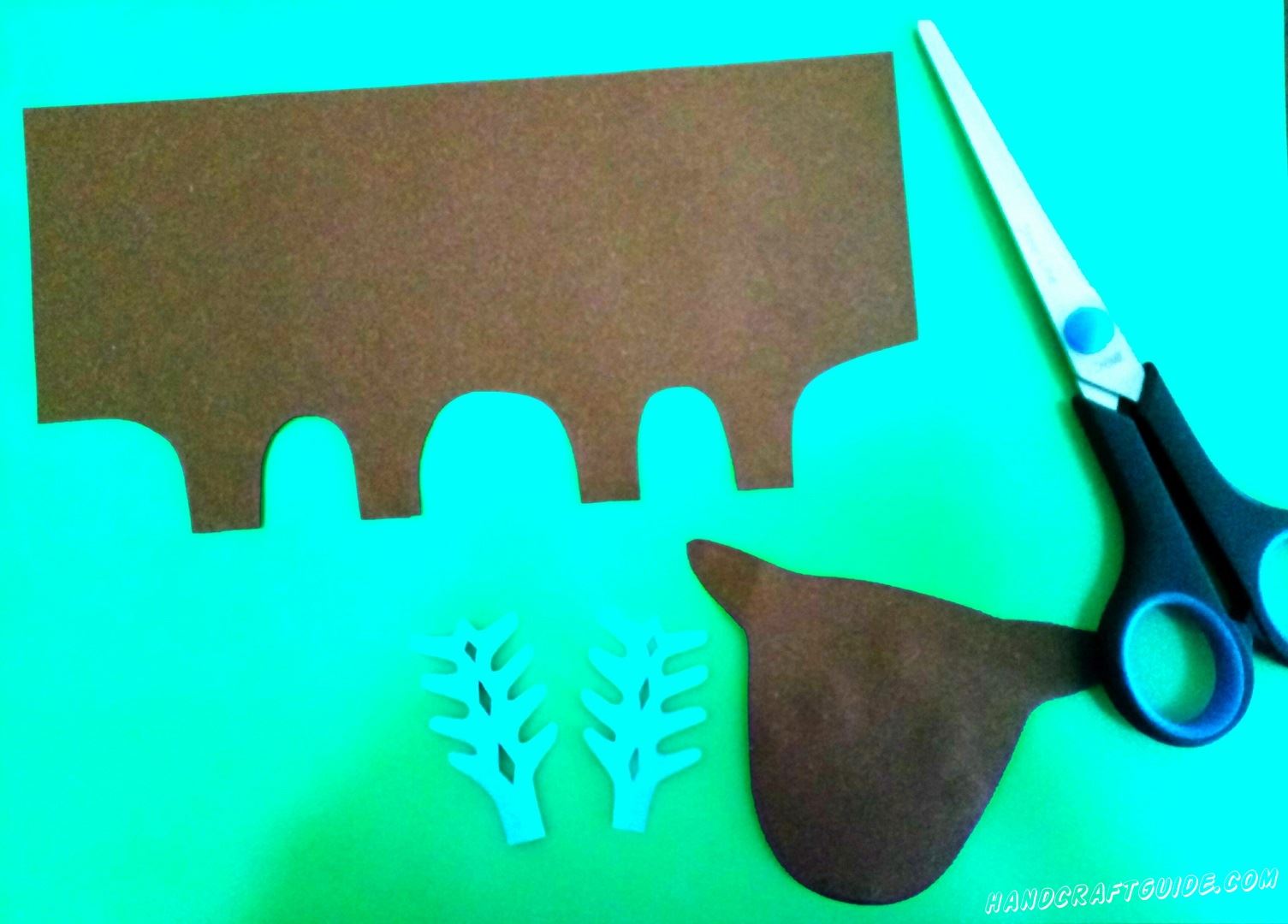 Cut out the head and trunk of brown paper. Then the horns are blue, as in the photo.