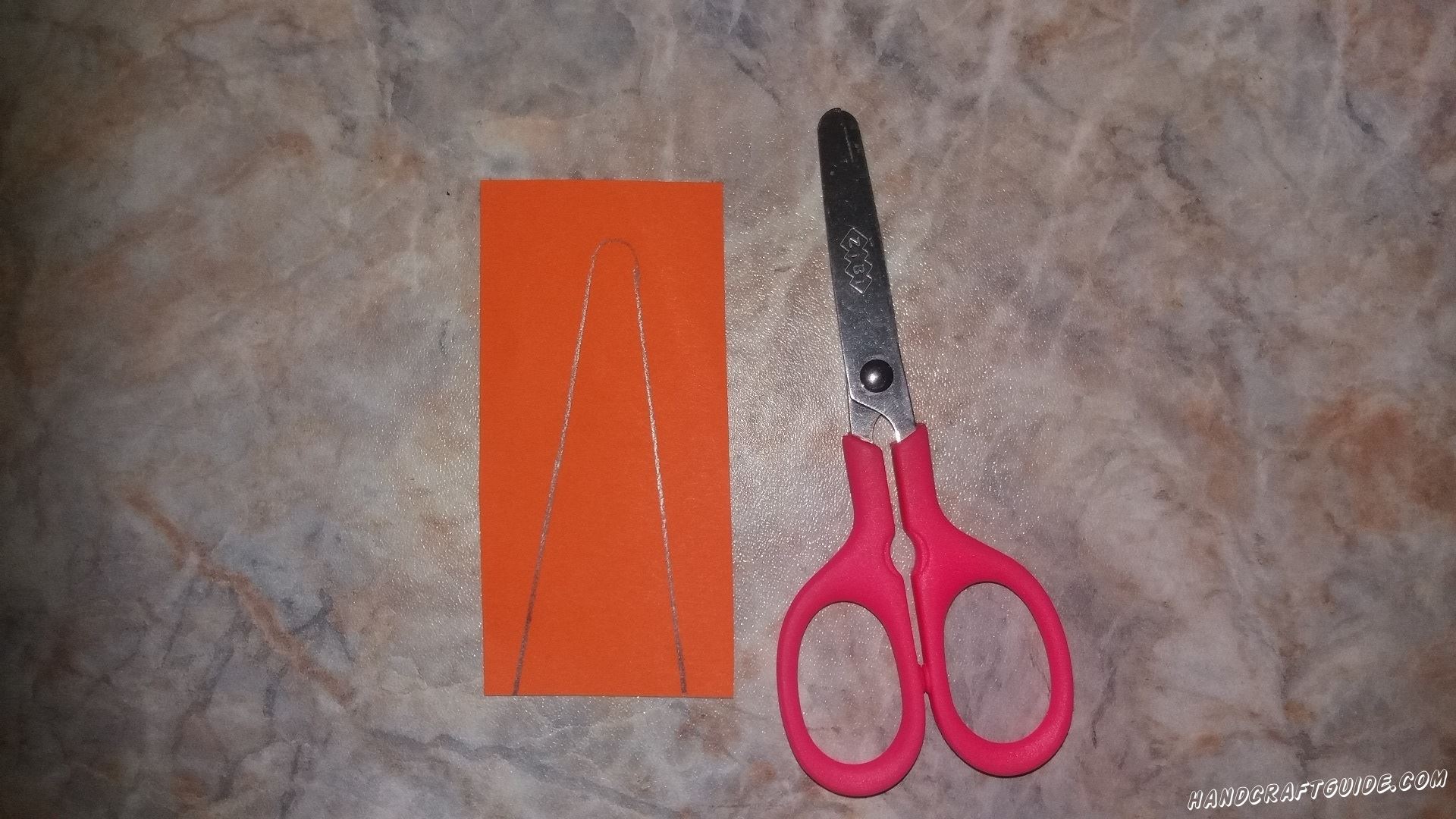 Затем берем оранжевую бумагу и вырезаем фигурку в форме морковки.